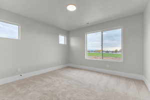 Empty room with light colored carpet and plenty of natural light