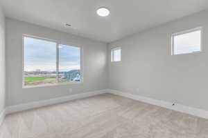 Spare room featuring light carpet and healthy amount of natural light