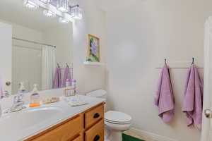 Bathroom featuring vanity, light tile patterned floors, and a shower with curtain