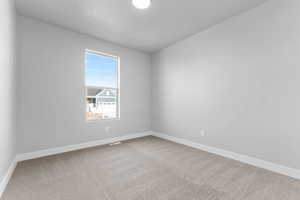 Empty room featuring baseboards and light carpet