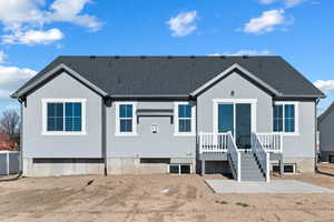 Back of house featuring roof with shingles, stucco siding, and a patio area