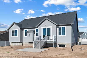 Rear view of property with roof with shingles, stucco siding, and a patio