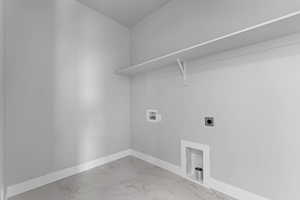 Laundry area with hookup for a washing machine, electric dryer hookup, and light marble finish flooring