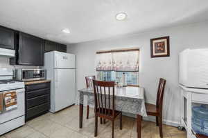 Dining room with a textured ceiling and light tile patterned flooring