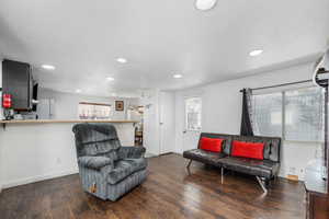 Living room with dark wood finished floors and recessed lighting