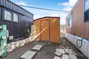 View of side of property featuring a storage shed