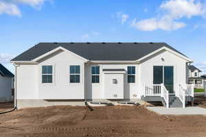 View of front of home featuring a shingled roof and stucco siding
