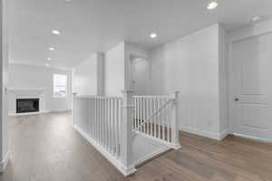Hallway featuring an upstairs landing, recessed lighting, and light wood-style flooring