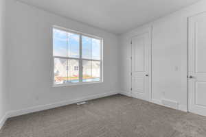 Unfurnished bedroom with baseboards and carpet flooring