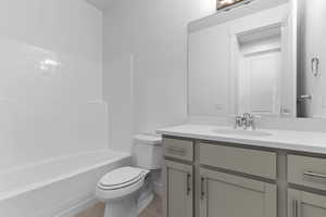 Bathroom featuring vanity,  shower combination, and light tile patterned floors