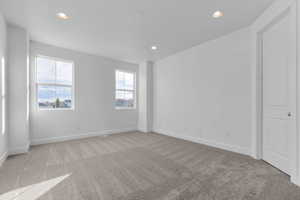 Unfurnished bedroom featuring light carpet and recessed lighting