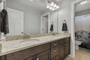 Bathroom with double vanity and light tile patterned flooring
