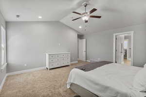 Bedroom featuring light carpet, lofted ceiling, and ceiling fan