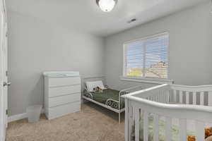 Bedroom featuring light carpet and a textured ceiling