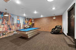 Recreation room featuring billiards, dark colored carpet, brick wall, a textured ceiling, and recessed lighting