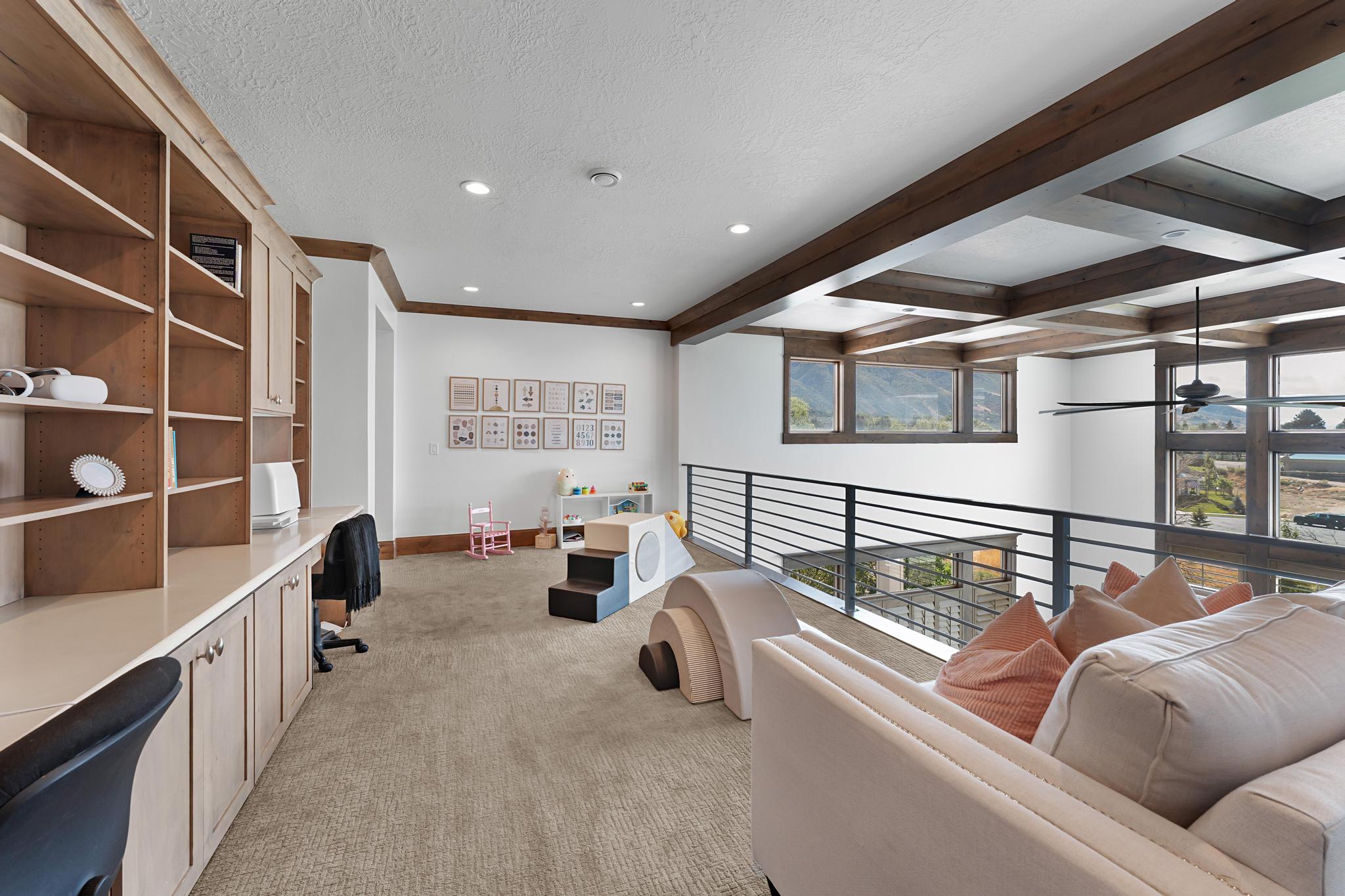 Sitting room featuring light colored carpet, built in desk, beam ceiling, recessed lighting, and a textured ceiling