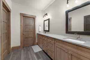 Bathroom with double vanity and dark wood finished floors