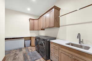 Laundry area featuring cabinet space, washer and clothes dryer, light wood-style floors, and recessed lighting