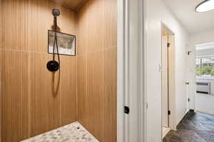 Bathroom featuring a tile shower and radiator