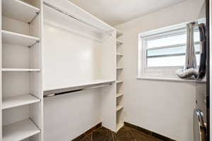 Walk in closet featuring dark tile patterned flooring