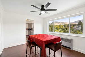 Dining room with ornamental molding, a mountain view, ceiling fan, and radiator heating unit