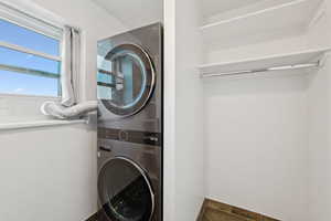 Washroom with stacked washer / drying machine and baseboards