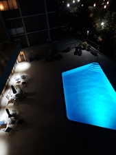 View of pool and patio at twilight
