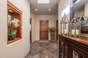 Corridor with recessed lighting, a skylight, and dark tile patterned floors