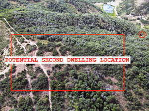 Aerial view of property's location featuring property parcel outlined and a forest