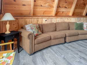 Living room with wood finished floors and wooden walls