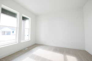 Carpeted spare room with baseboards