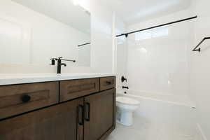 Bathroom with vanity, tub / shower combination, and light marble finish flooring