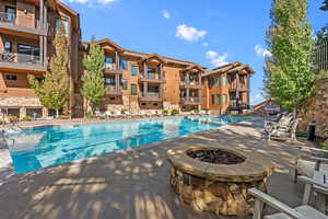 Community pool with an outdoor fire pit and a patio