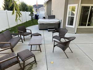 View of patio / terrace with a hot tub and an outdoor living space