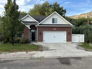 Ranch-style home with board and batten siding, concrete driveway, a garage, and brick siding