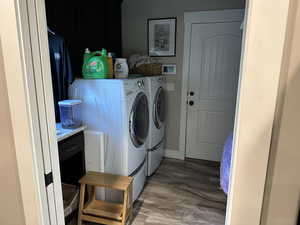 Washroom with independent washer and dryer and light wood finished floors