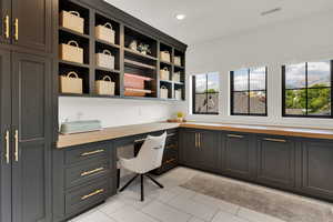 Laundry/craft area of laundry room featuring built in desk, light tile patterned floors, and recessed lighting