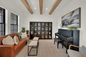 Living area featuring beam ceiling and recessed lighting