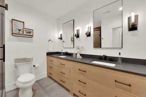 Bathroom with double vanity and light tile patterned floors