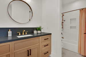 Bathroom with vanity, shower / bath combo, and light tile patterned flooring