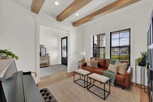 Living area with beam ceiling, light wood-style flooring, and recessed lighting