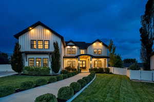 Modern farmhouse style home with board and batten siding, a standing seam roof, a gate, and a metal roof