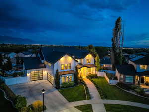 Modern inspired farmhouse featuring concrete driveway, board and batten siding, a metal roof, a standing seam roof, and a gate
