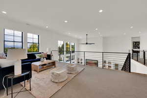 Carpeted living area featuring recessed lighting and ceiling fan