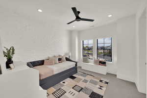 Bedroom featuring light colored carpet, ceiling fan, brick wall, and recessed lighting