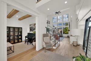 Living area featuring recessed lighting, light wood finished floors, beamed ceiling, stairway, and a ceiling fan