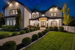 Modern inspired farmhouse featuring board and batten siding and a yard