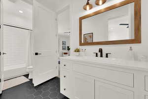 Bathroom featuring vanity, shower / tub combo, dark tile patterned floors, and recessed lighting