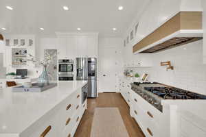 Kitchen featuring glass insert cabinets, white cabinetry, appliances with stainless steel finishes, recessed lighting, and dark wood finished floors