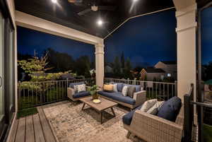 Balcony at night featuring an outdoor hangout area and ceiling fan